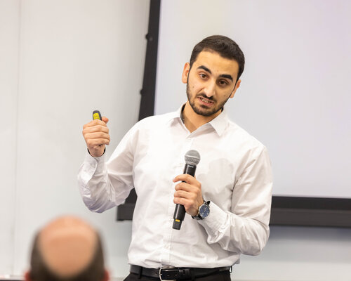 Male student presenting at a business model competition