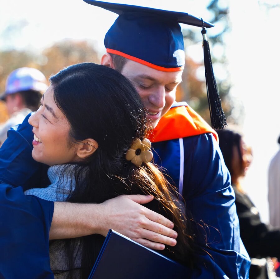 Recent masters graduate hugging family