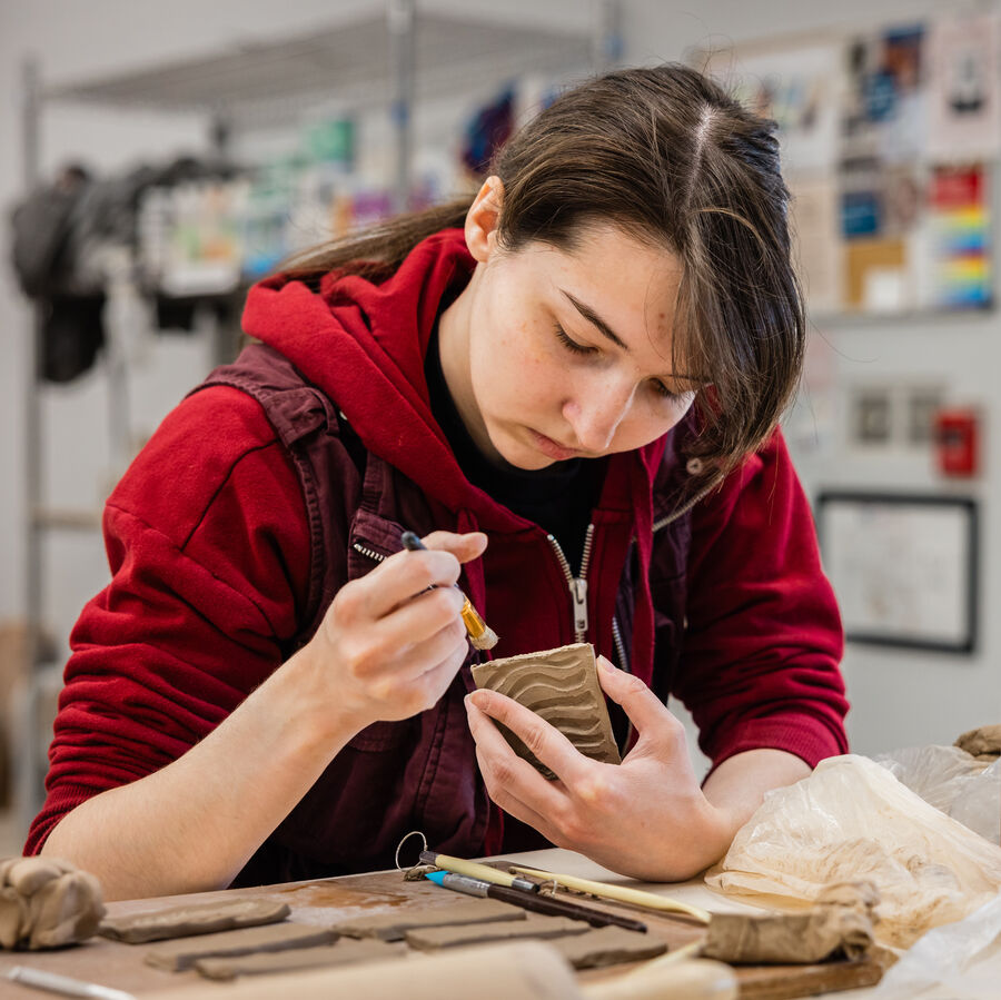 A female BFA student works with clay in UT Tyler's Art Department