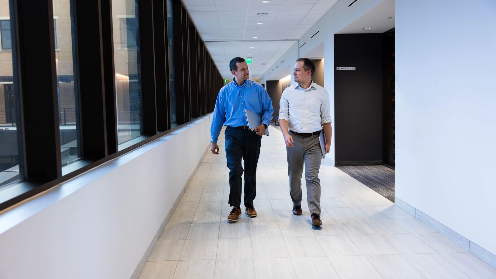 Two male students from the MBA in Healthcare Management walk through a hallway in the Soules College of Business at UT Tyler