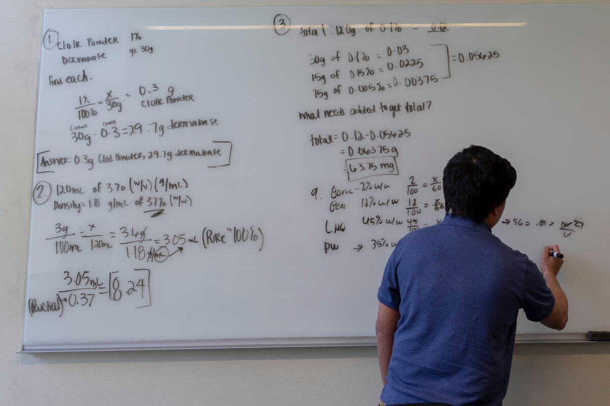 A student doing math on a whiteboard