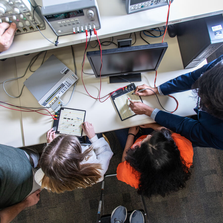 A professor and students interacting on an electrical engineering project at The University of Texas at Tyler
