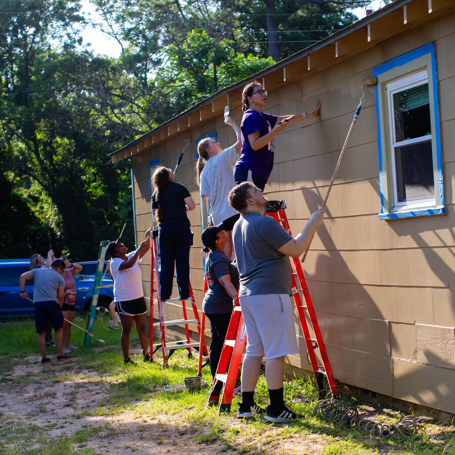 Medicine students volunteering to paint a house in the Tyler community