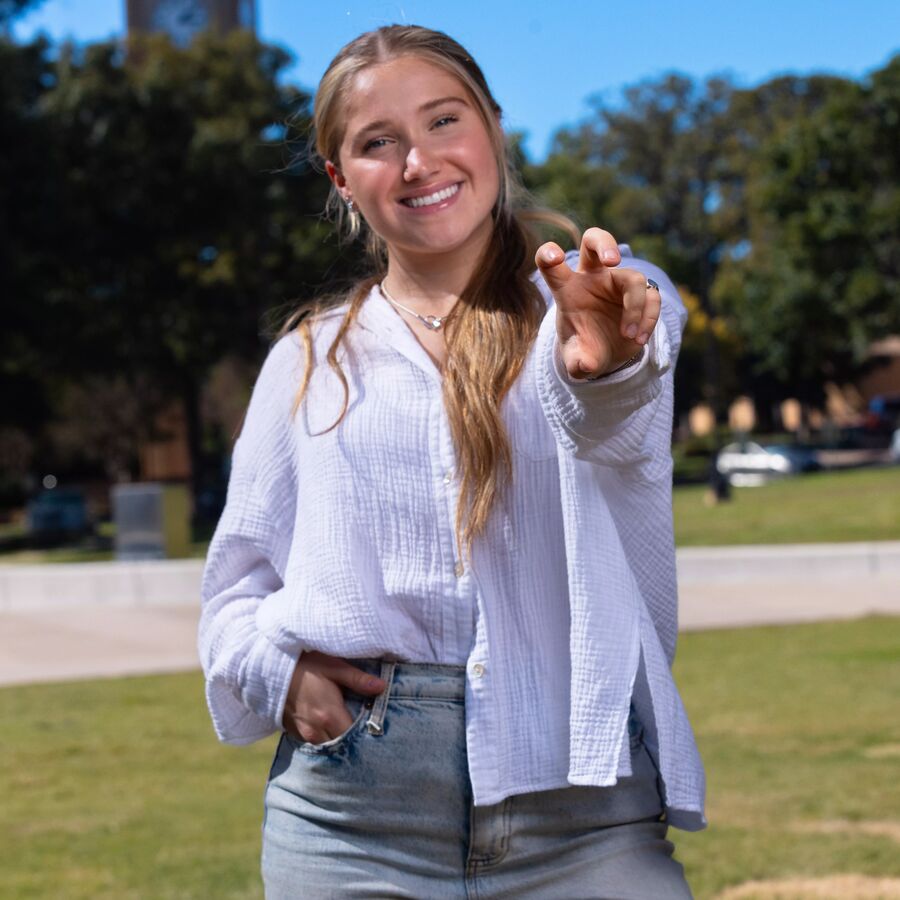 A female UT Tyler student with her hand held out like a bird talon