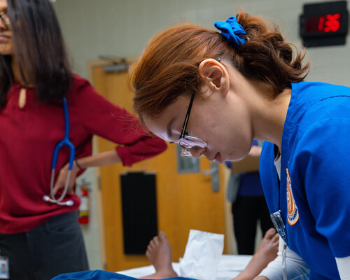 A female nursing student practicing in a simulation lab