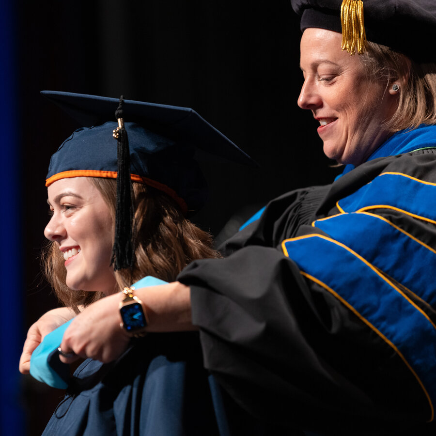 A student being presented with a sash at graduation