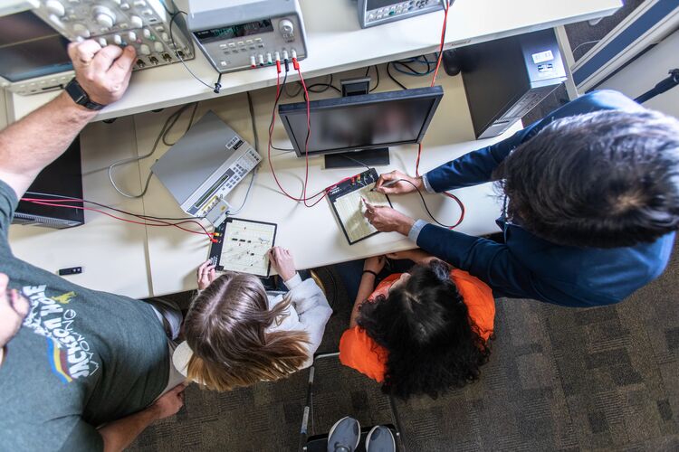 Electrical Engineering students looking at a board