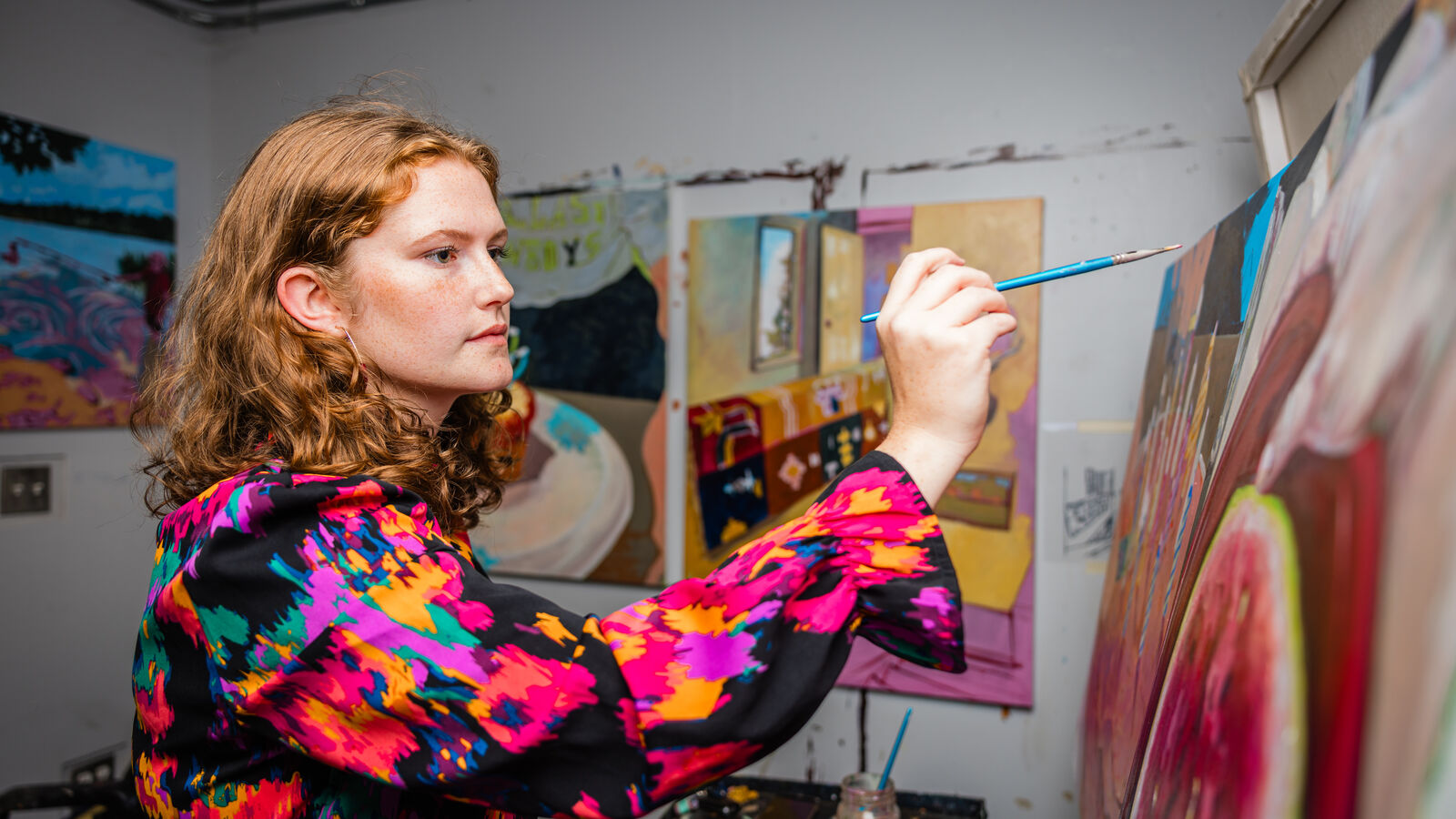 A female BFA student paints a picture of fruit in UT Tyler's Art Department