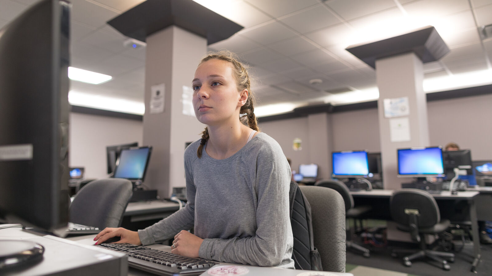 A female computer information systems student works in a computer lab at The University of Texas at Tyler
