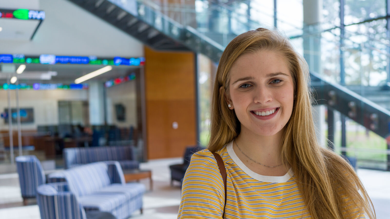 A female student stands in a common area in the Soules College of Business at The University of Texas at Tyler