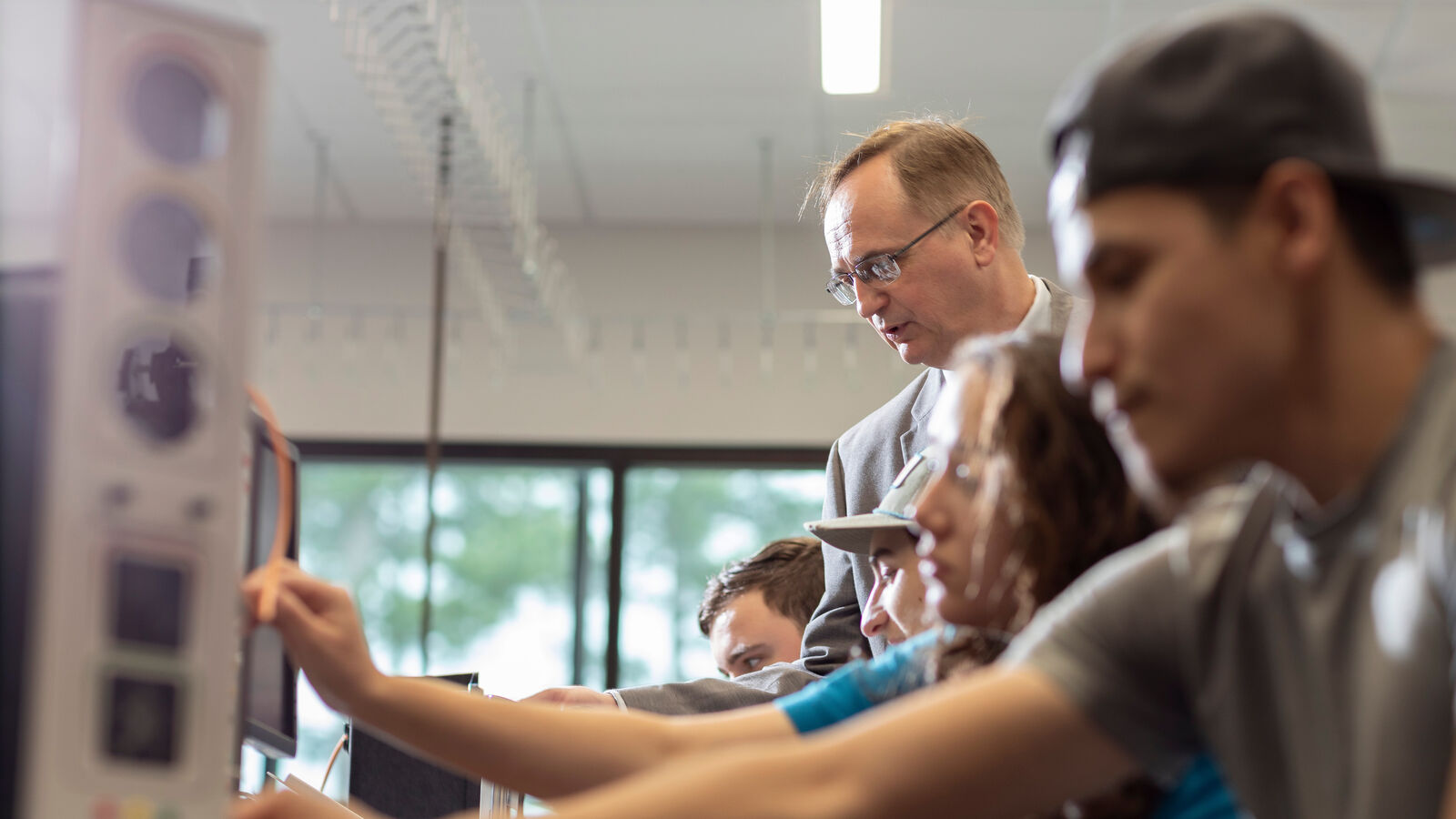 Industrial Technology majors with a professor in a robotics lab at UT Tyler.