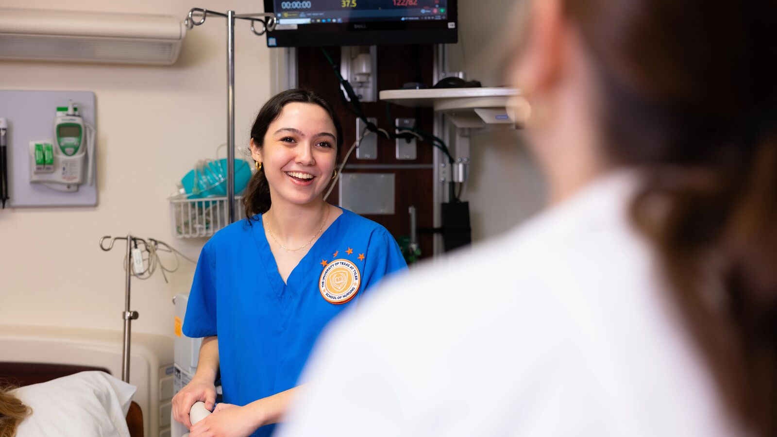 Two female pre-med students in a simulation space at The University of Texas at Tyler