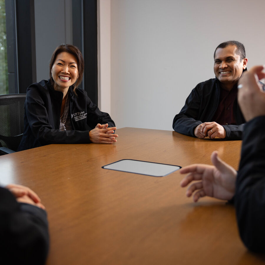 Students in UT Tyler's executive MBA in healthcare management program sit around a table having a discussion