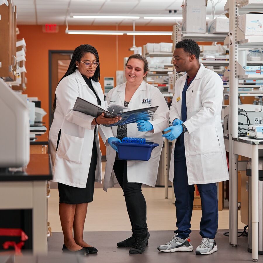 A group of Fisch College of Pharmacy students in lab coats at The University of Texas at Tyler