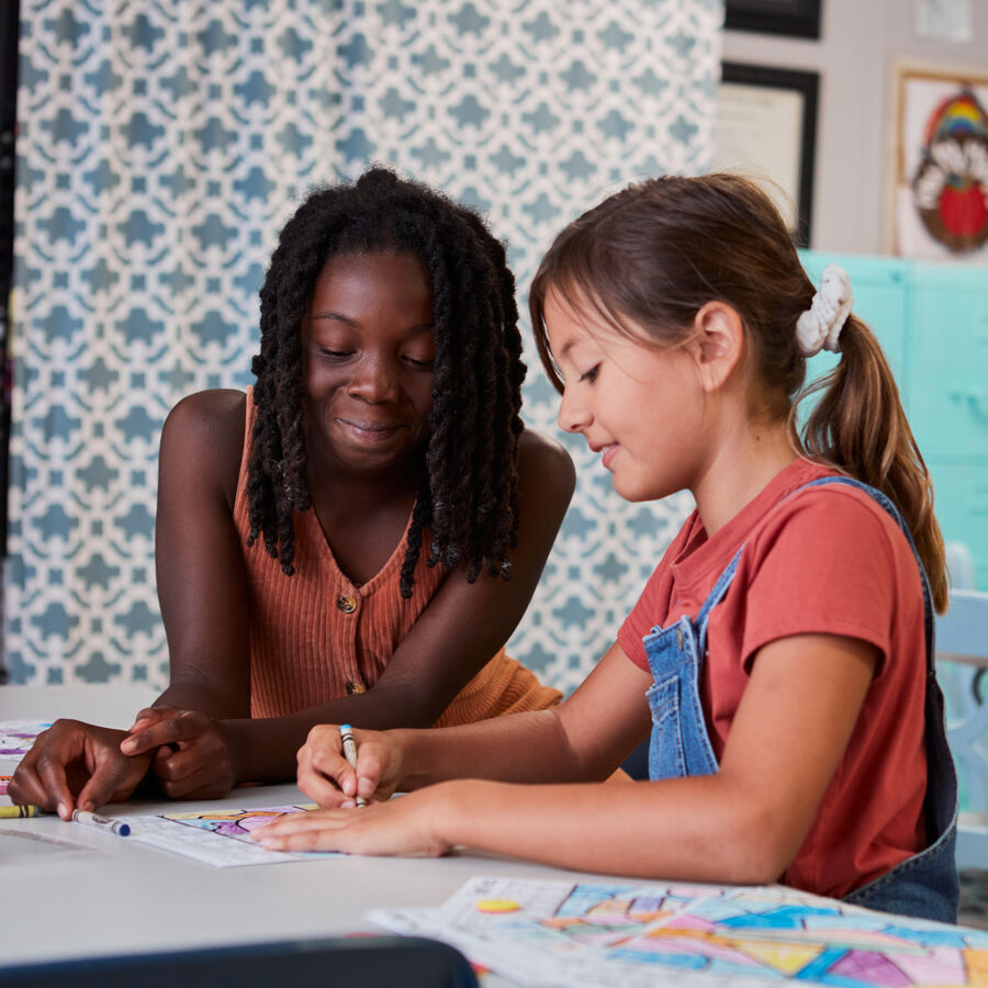 Two elementary school students color together at a table at UT Tyler University Academy Longview