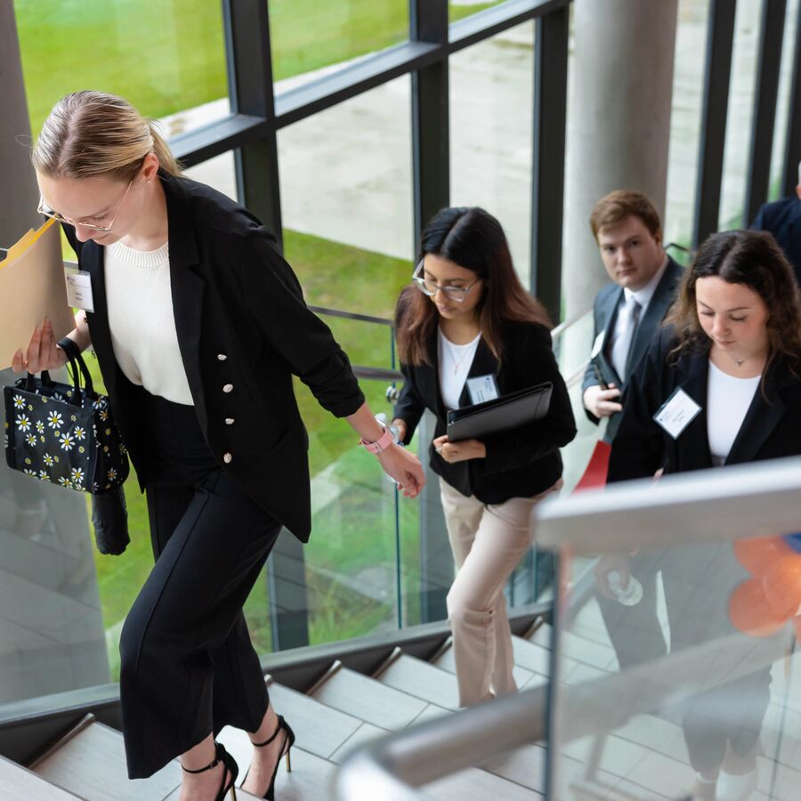 A group of Soules College of Business Students walk up a flight of stairs during a mock interview event