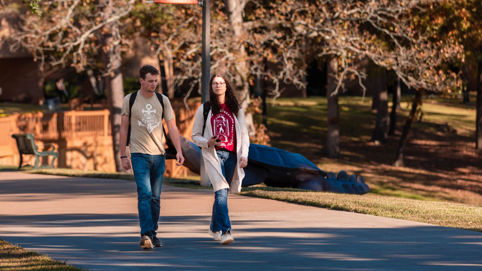 Two University of Texas at Tyler students walk along a path outdoors