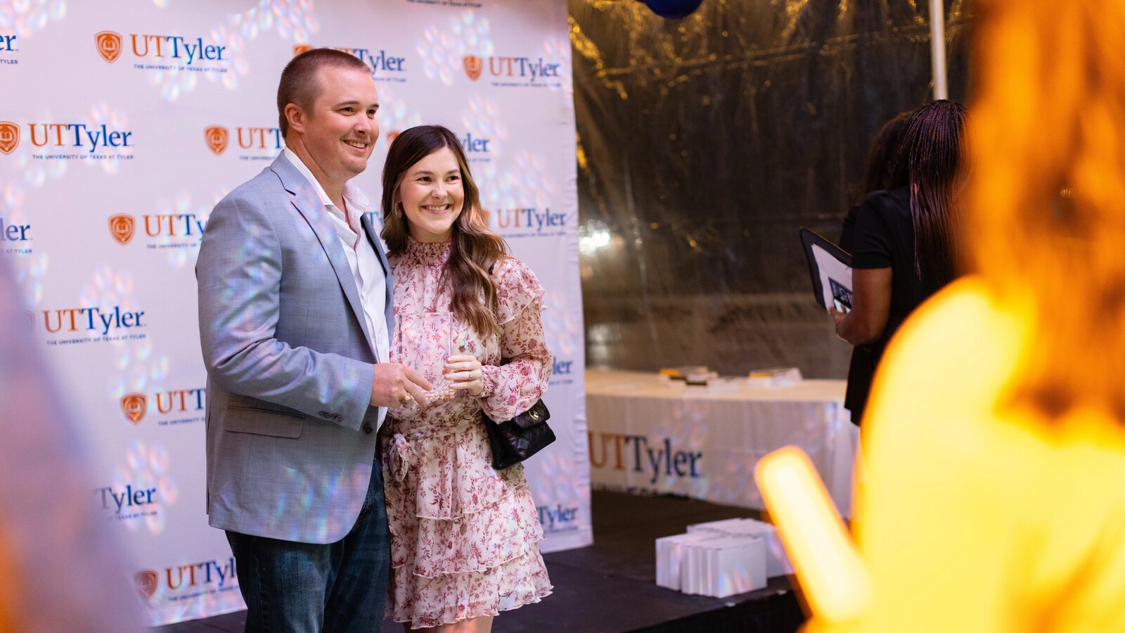 A group of donors holds a large check in making a donation to The University of Texas at Tyler