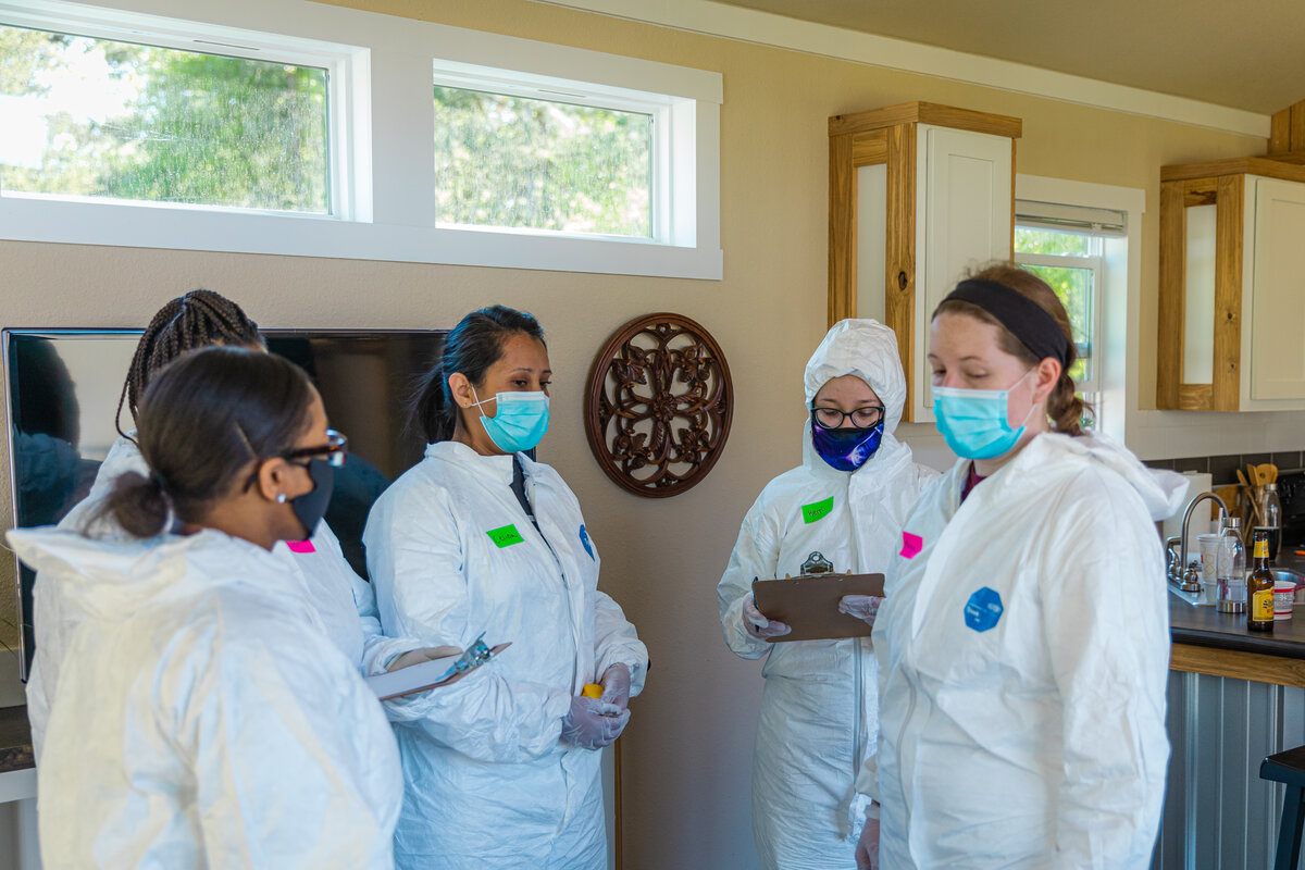 Criminal Justice students in white safety gear in a Crime Scene Simulation