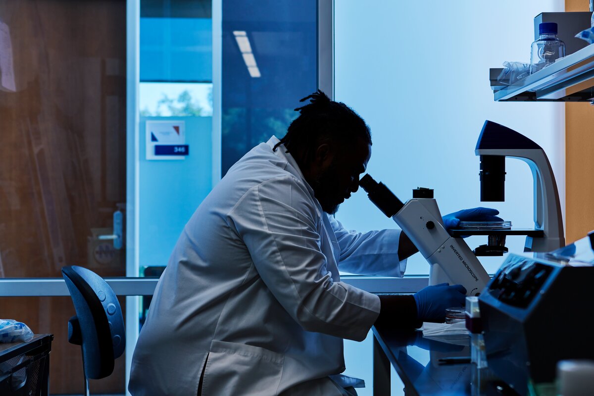 Scientist looking down a microscope