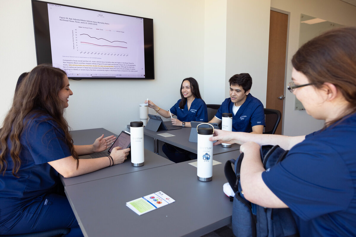 Students around a table talking and studying together