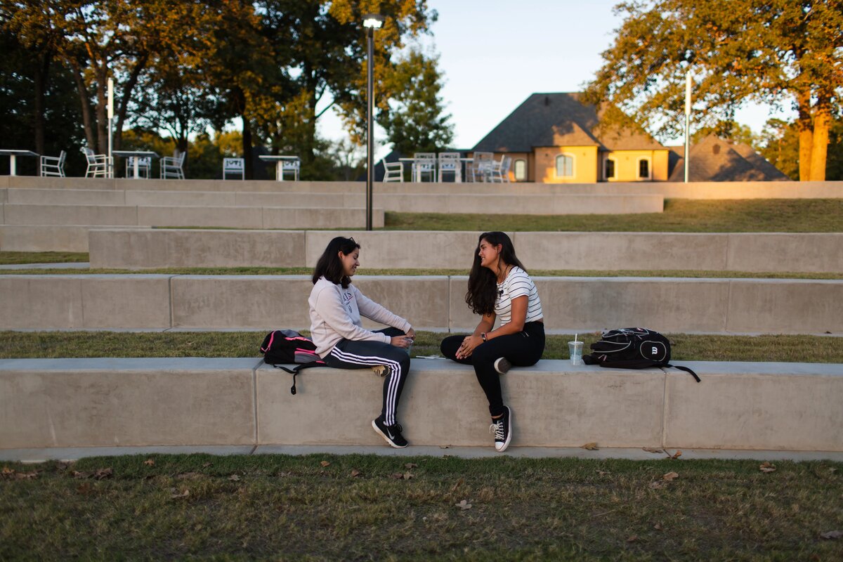 Two students talking on concrete steps