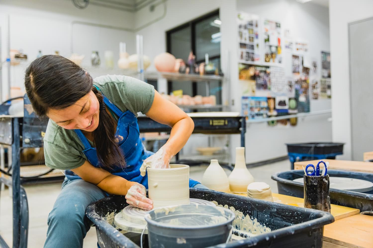 A female College of Arts and Sciences student making pottery in class