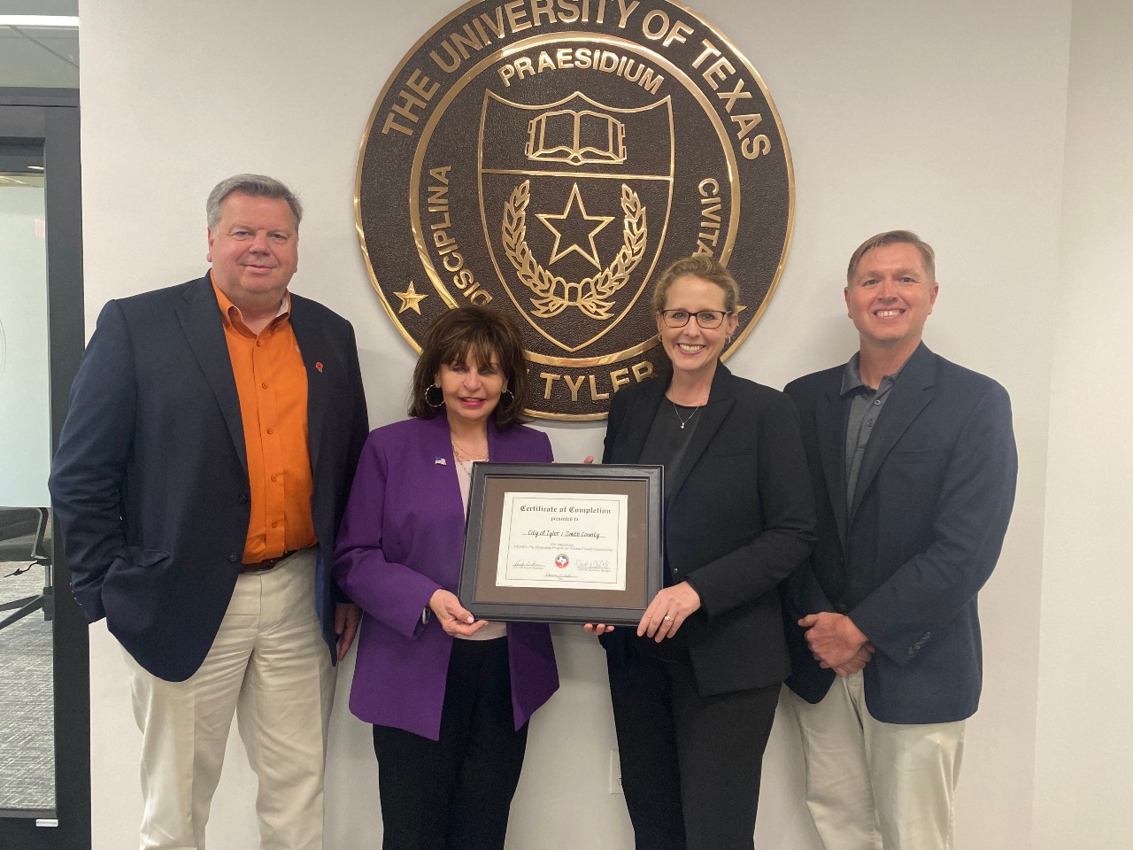 Photo of Dean Swimberghe, Dr. Young, President Philley and Chair James presenting Young with city of Tyler award