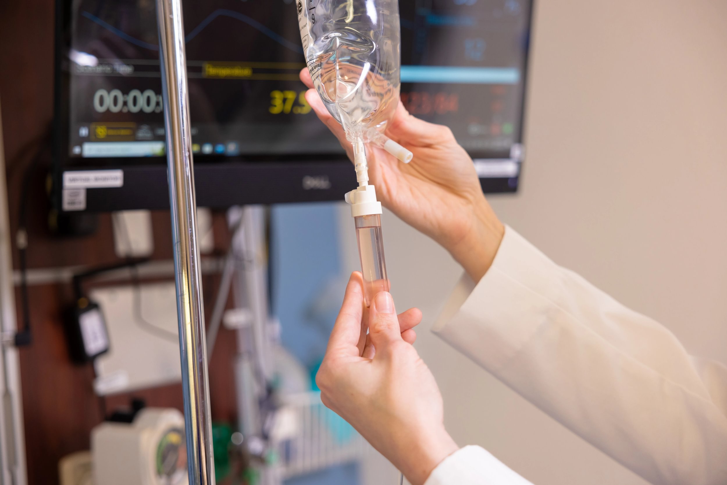 Photo of Faculty Member Holding Sim Hospital IV on Display