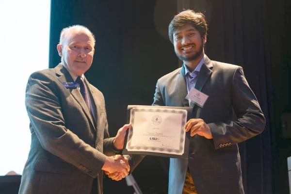Photo of Ahmed receiving award at forum at LSU-S