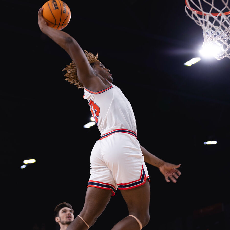 A student makes a slam dunk at a basketball game at UT Tyler