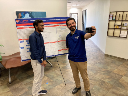 Students taking a selfie in front of a research poster.