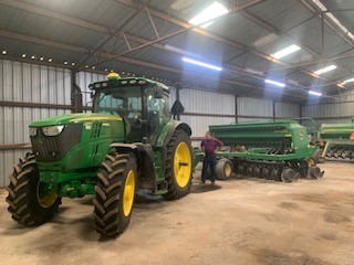 Green tractor sitting in warehouse