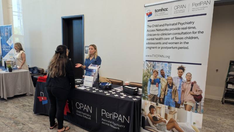 Staff standing at table during conference