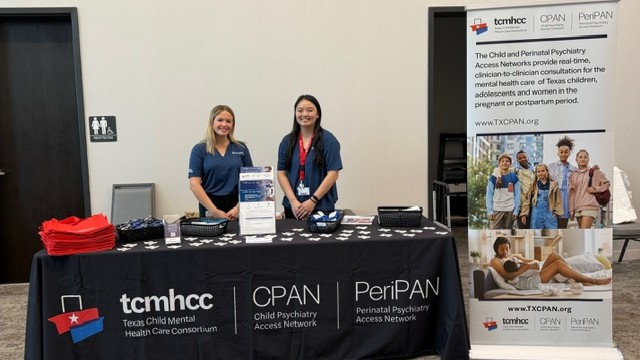 Staff standing at table during conference