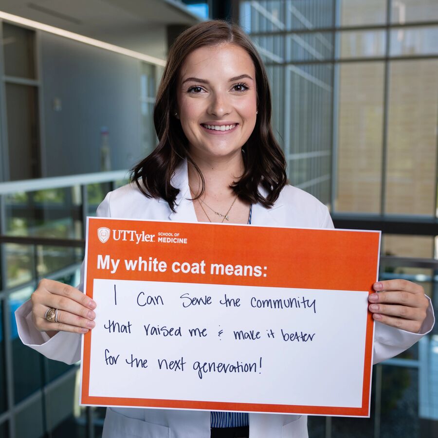 mccartney holding her sign and wearing a white coat