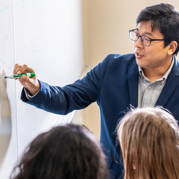 teacher explaining a lesson using a whiteboard