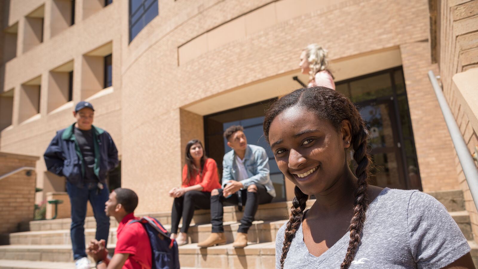 Students standing outside the stairs of a college building