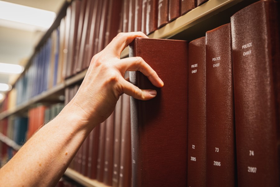 Hand pulling out a book from a book shelf