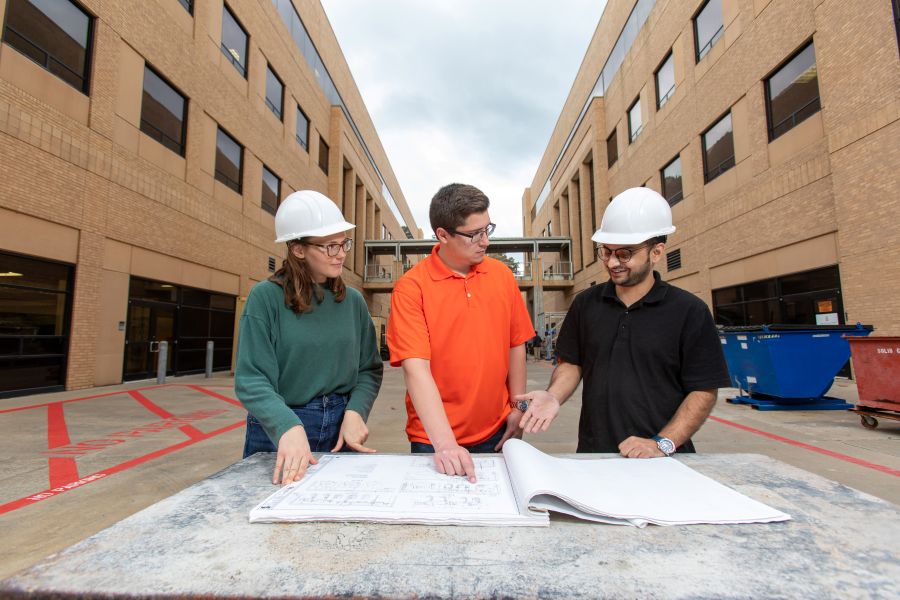 Three people looking at a plan of action