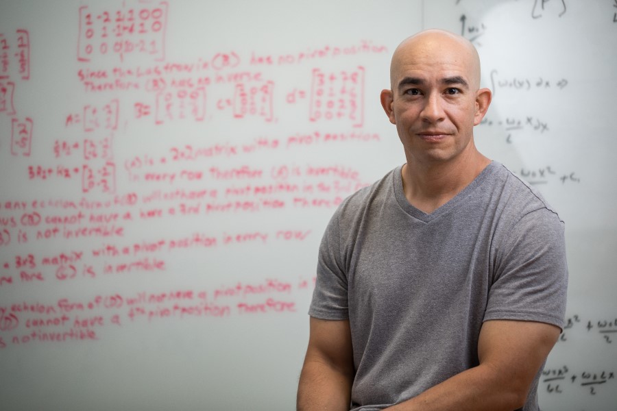 Professors in front of a dry erase board with calculations